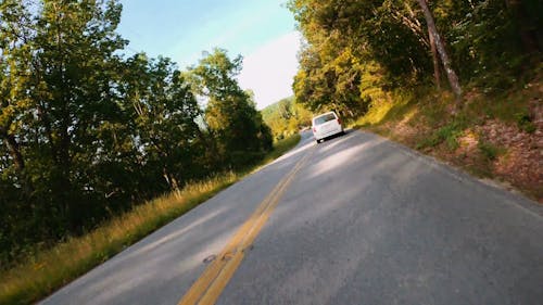 A Motorbike Rider Traversing A Long Road