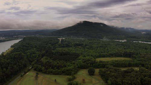 Drone Footage Of The Woods With View Of Mountain Under A Cloudy Sky