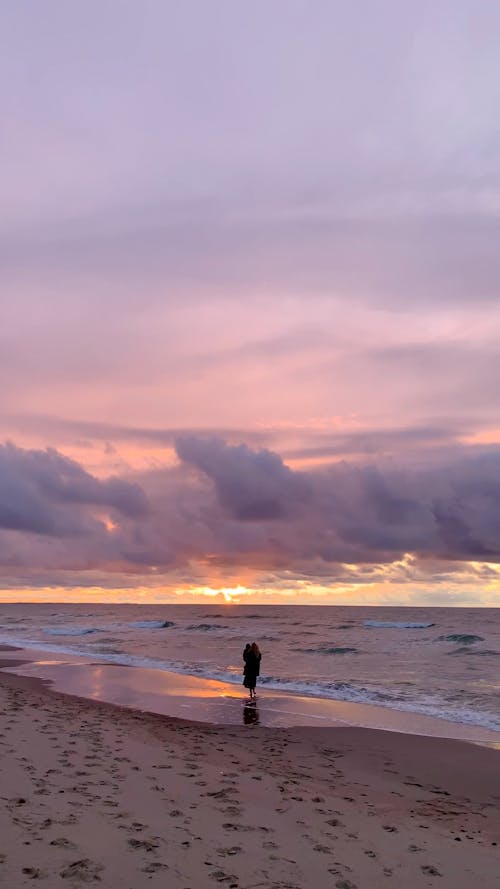 A Person Walking on the Seashore
