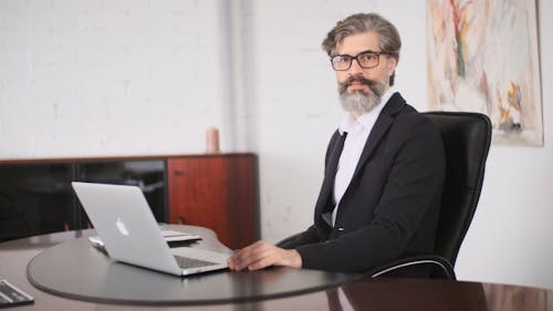 A Businessman Sitting In His Office With Laptop 
