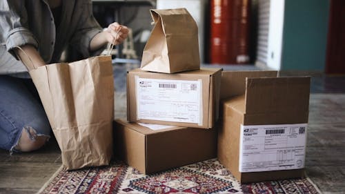 A Woman Checking The Content Of A Paper Bag