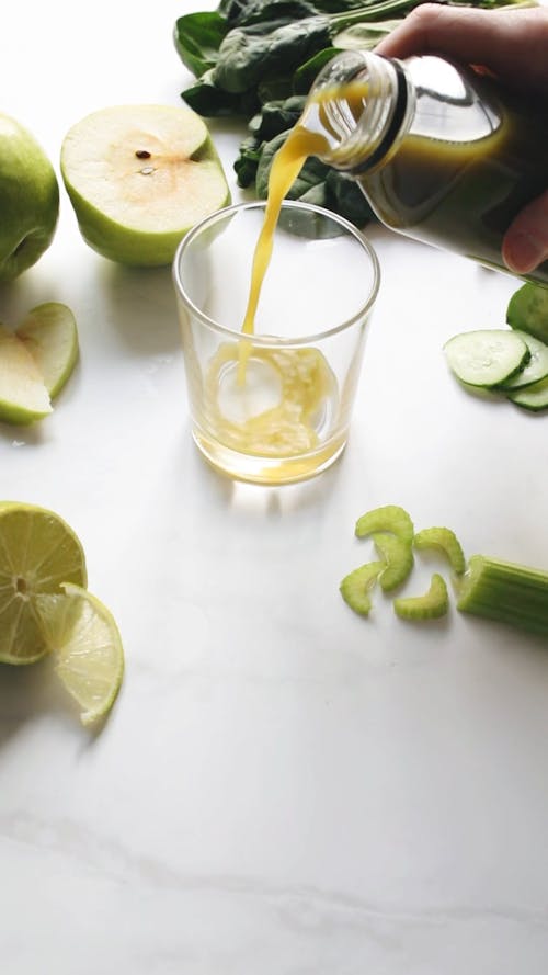 A Close-up Shot of a Person Pouring Fruit Juice into a Cup