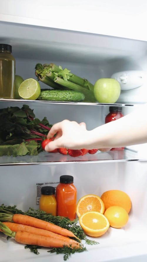 A Person Taking Fresh Strawberry from the Fridge