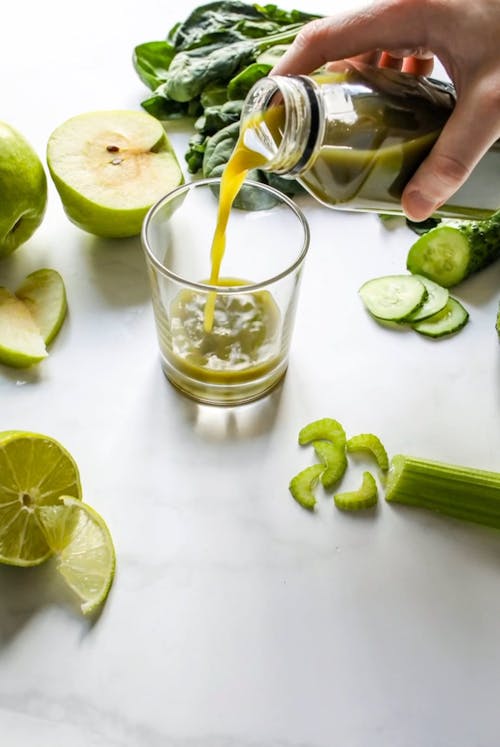 Person Pouring Green Juice