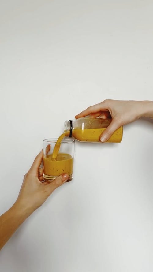 Pouring Vegetable Juice into a Cup