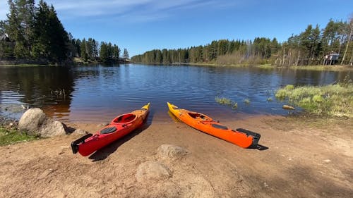 Two Orange Kayaks on Shore