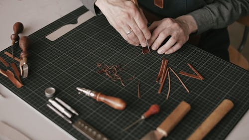 A Person Cutting the Leather