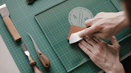 A Person Using a Skiver on a Piece of Leather