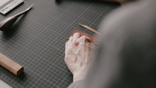 A Person Using a Beveler on a Piece of Leather