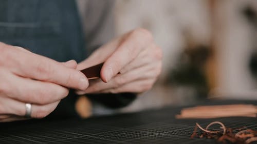 A Man Working On A Piece Of Leather