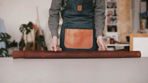 A Person Rolling Out the Leather on the Table