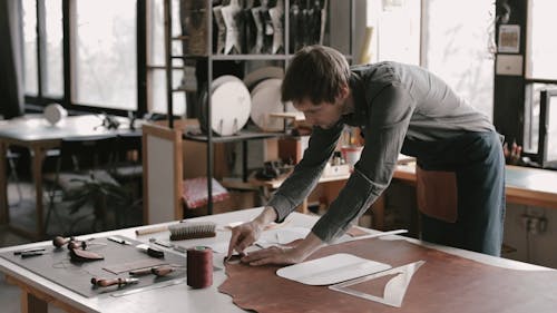 A Leather Worker Measuring The Leather Material 