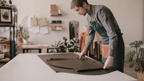 A Man Rolling Out the Leather on the Table