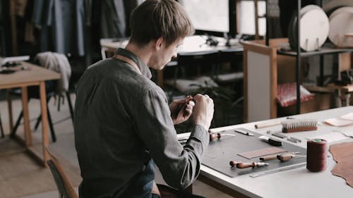 A Man Sewing the Leather