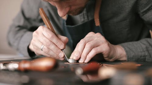 A Close up of a Man Shaping a Piece of Leather