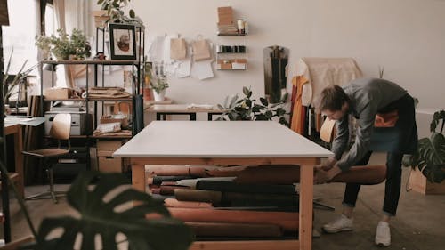 Man Put a Roll of Leather on the Table