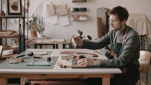 Man Putting Brown Thread on the Needle