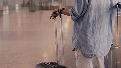 person holding his luggage