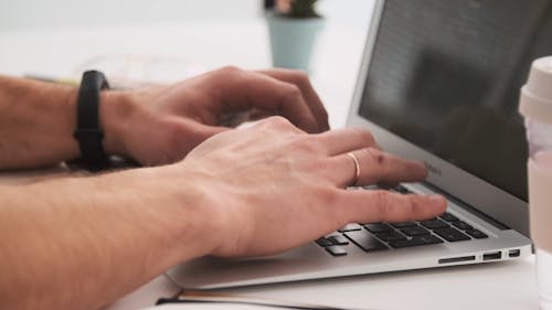 Person Busy Typing on the Laptop