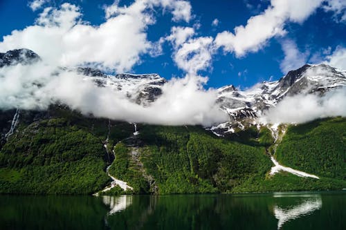 Time Lapse of Snow Capped Mountains near a Body of Water