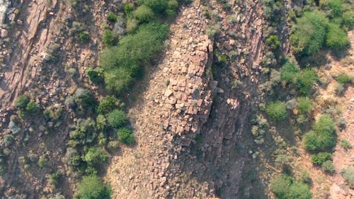 Drone Footage of Couple Lying on the Ground on Top of the Mountain