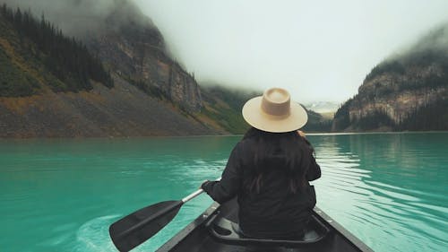 A Woman Paddling A Boat In Lake Louise 