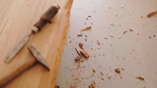 Using Chisel And Hammer To Chip A Wood