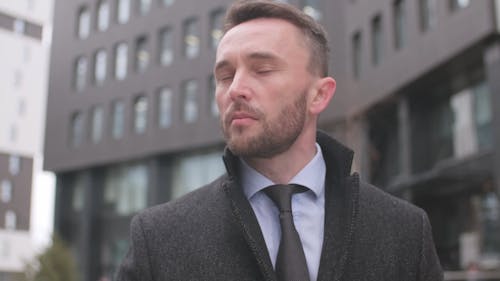 A Man Walking and Sipping Coffee