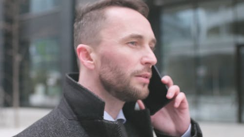 Close up of a Man Talking on a Cellphone while Walking