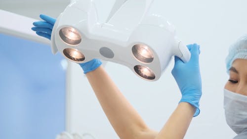 Dentist Pulling Down The Dental Chair Light