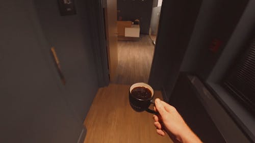 Bringing A Cup Of Black Coffee Inside An Office Room