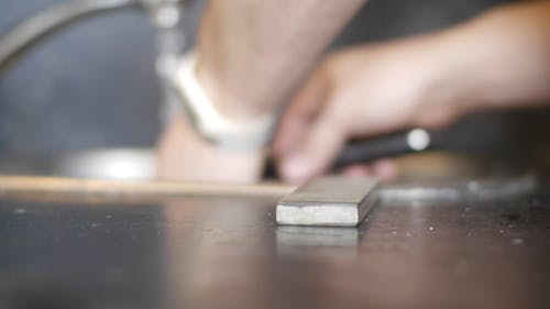 Person Sharpening His Knife