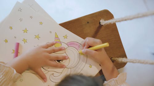 Little Girl Coloring a Unicorn