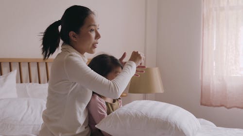 A Mother Clipping Her Daughter's Hair