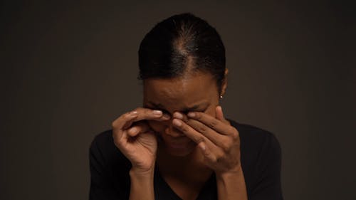 A Woman Crying and Wiping Her Tears