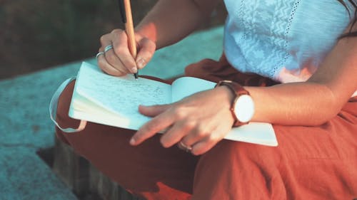 A Woman Writing On A Journal