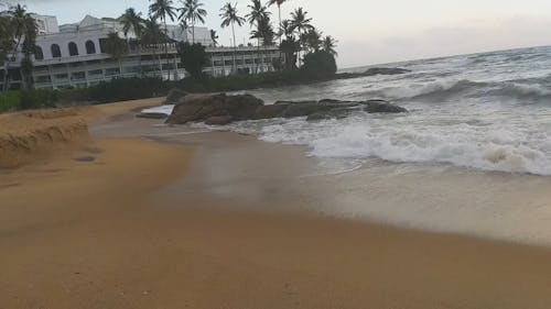 Waves Crashing On Rocks By The Seashore