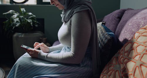 A Woman Using Her Cellphone At Home