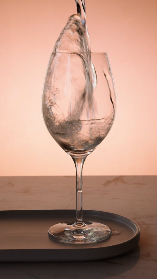 A Person Pouring Water in the Glass