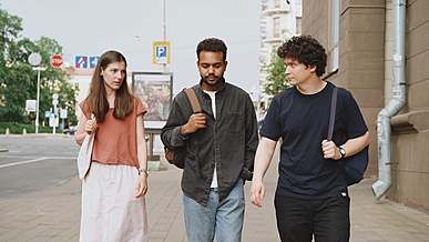 people having conversation while walking on sidewalk