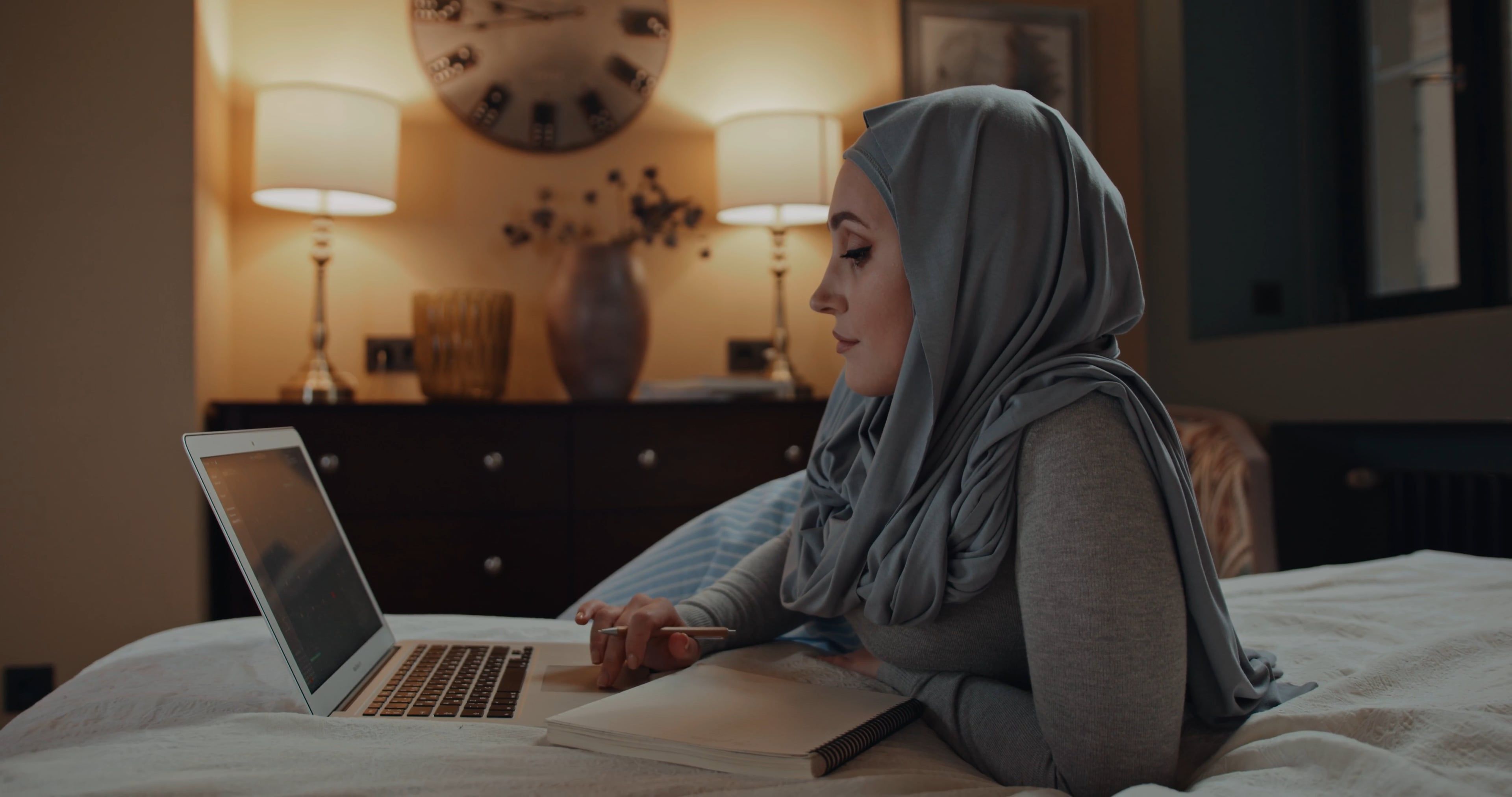 Woman in a Hijab Looking at a Laptop and Taking Notes · Free Stock Video