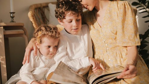 A Mother Reading A Book With Childer