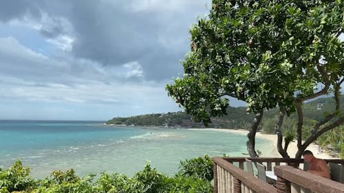 A Man Eating at the Balcony with a Beach View