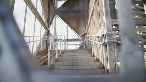 Man Carrying a Bike while Going Down the Stair
