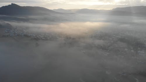 An Aerial Footage of a Town Covered in Mist