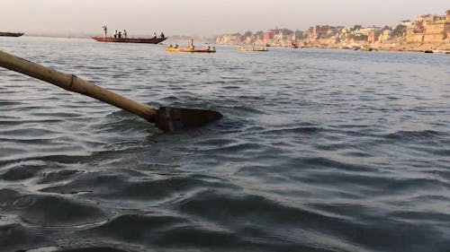 Passenger Rowing A Boat With A Paddle