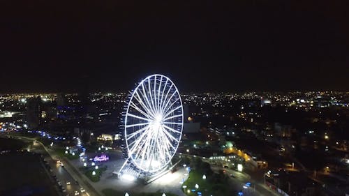 Drone Footage of a Ferris Wheel in the City at Night