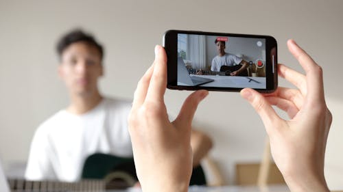 Recording a Video of a Man Playing the Guitar