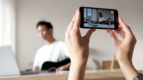 Shallow Focus of Person's Hand Holding and Recording through the Smartphone