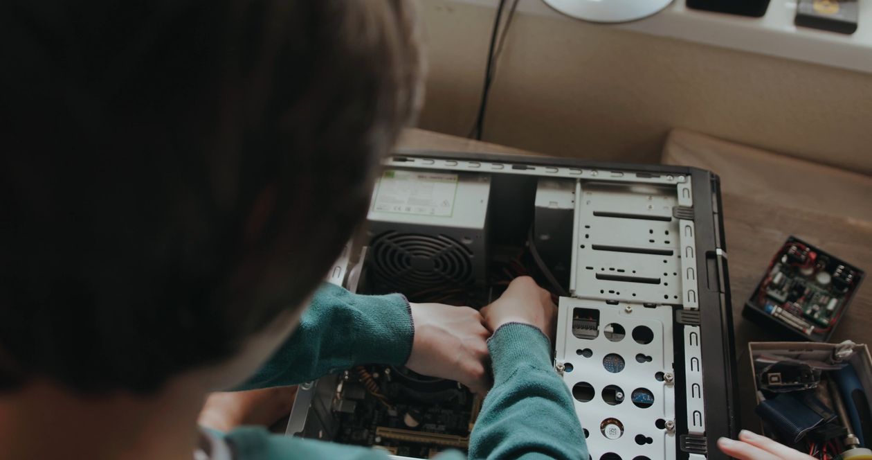 Mãos realizando manutenção técnica em computador durante diagnóstico de desempenho